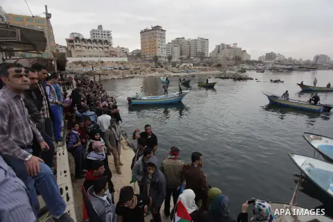 Palestinians look at boats leaving as a convoy is launched at the initiative of the "Intifada Youth Coalition" (IYC) to break the naval blockade of Gaza as a protest against the Israeli siege on December 2, 2013 at the p...