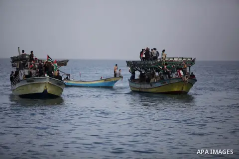 Palestinians sail their boats as part of a convoy that was launched at the initiative of the "Intifada Youth Coalition" (IYC) to break the naval blockade of Gaza as a protest against the Israeli siege on December 2, 2013...