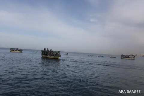 Palestinians sail their boats as part of a convoy that was launched at the initiative of the "Intifada Youth Coalition" (IYC) to break the naval blockade of Gaza as a protest against the Israeli siege on December 2, 2013...