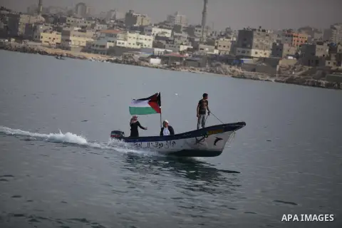 Palestinians sail their boats as part of a convoy that was launched at the initiative of the "Intifada Youth Coalition" (IYC) to break the naval blockade of Gaza as a protest against the Israeli siege on December 2, 2013...