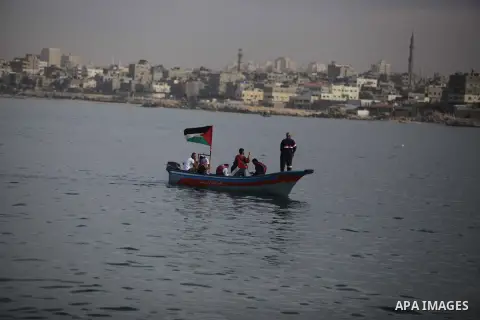 Palestinians sail their boats as part of a convoy that was launched at the initiative of the "Intifada Youth Coalition" (IYC) to break the naval blockade of Gaza as a protest against the Israeli siege on December 2, 2013...