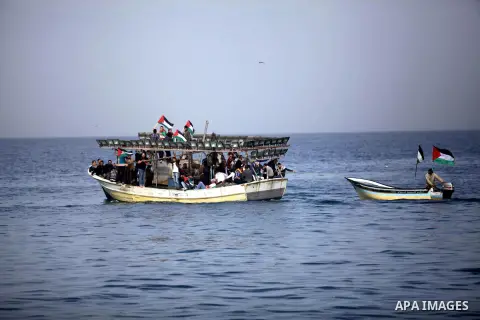 Palestinians sail their boats as part of a convoy that was launched at the initiative of the "Intifada Youth Coalition" (IYC) to break the naval blockade of Gaza as a protest against the Israeli siege on December 2, 2013...
