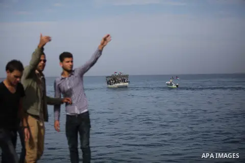 Palestinians wave to a convoy of boats leaving the port of Gaza at the initiative of the "Intifada Youth Coalition" (IYC) to break the naval blockade of Gaza as a protest against the Israeli siege on December 2, 2013 in...