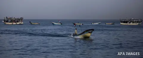 Palestinians sail their boats as part of a convoy that was launched at the initiative of the "Intifada Youth Coalition" (IYC) to break the naval blockade of Gaza as a protest against the Israeli siege on December 2, 2013...