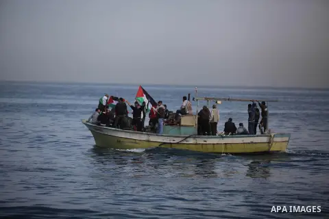 Palestinians sail their boats as part of a convoy that was launched at the initiative of the "Intifada Youth Coalition" (IYC) to break the naval blockade of Gaza as a protest against the Israeli siege on December 2, 2013...