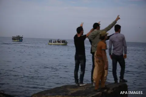 Palestinians wave to a convoy of boats leaving the port of Gaza at the initiative of the "Intifada Youth Coalition" (IYC) to break the naval blockade of Gaza as a protest against the Israeli siege on December 2, 2013 in...