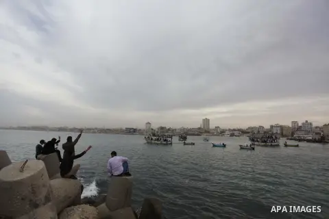 Palestinians sail their boats as part of a convoy that was launched at the initiative of the "Intifada Youth Coalition" (IYC) to break the naval blockade of Gaza as a protest against the Israeli siege on December 2, 2013...