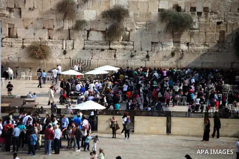 Jewish worshippers stand near a Menorah during the holiday of Hanukkah, at the Western Wall, Judaism's holiest prayer site, in Jerusalem's Old City December 4, 2013. Photo by Saeed Qaq
