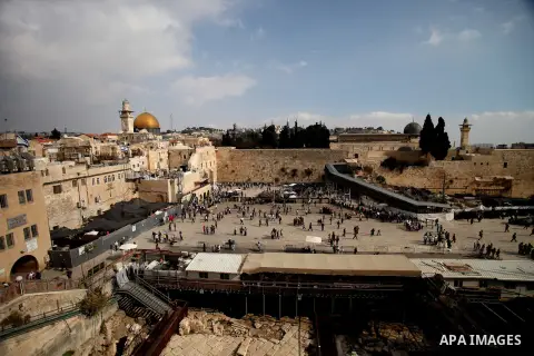 Jewish worshippers stand near a Menorah during the holiday of Hanukkah, at the Western Wall, Judaism's holiest prayer site, in Jerusalem's Old City December 4, 2013. Photo by Saeed Qaq