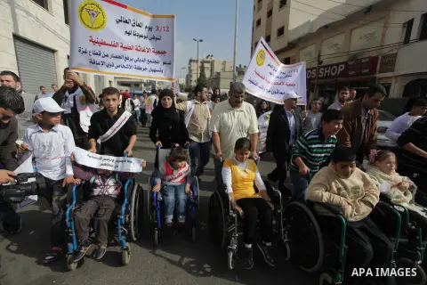 Palestinians and physically challenged people take part in a rally marking the International Day of Persons with Disabilities in Gaza City on Dec. 04, 2013. According to a United Nations report on disabilities, physical,...