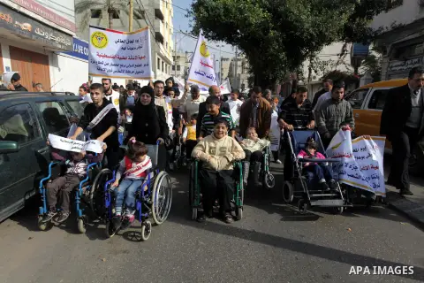 Palestinians and physically challenged people take part in a rally marking the International Day of Persons with Disabilities in Gaza City on Dec. 04, 2013. According to a United Nations report on disabilities, physical,...