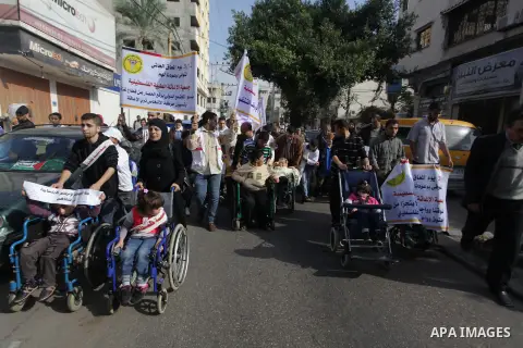 Palestinians and physically challenged people take part in a rally marking the International Day of Persons with Disabilities in Gaza City on Dec. 04, 2013. According to a United Nations report on disabilities, physical,...