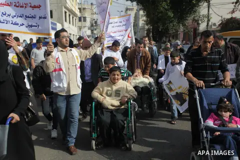 Palestinians and physically challenged people take part in a rally marking the International Day of Persons with Disabilities in Gaza City on Dec. 04, 2013. According to a United Nations report on disabilities, physical,...