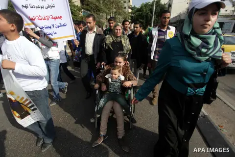 Palestinians and physically challenged people take part in a rally marking the International Day of Persons with Disabilities in Gaza City on Dec. 04, 2013. According to a United Nations report on disabilities, physical,...