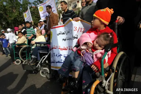 Palestinians and physically challenged people take part in a rally marking the International Day of Persons with Disabilities in Gaza City on Dec. 04, 2013. According to a United Nations report on disabilities, physical,...