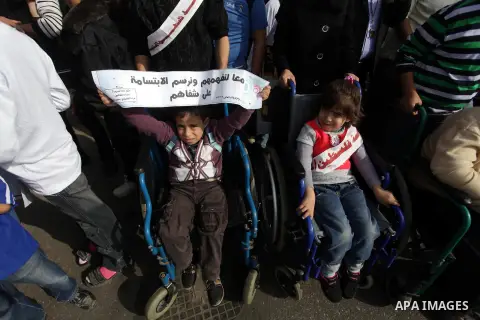 Palestinians and physically challenged people take part in a rally marking the International Day of Persons with Disabilities in Gaza City on Dec. 04, 2013. According to a United Nations report on disabilities, physical,...