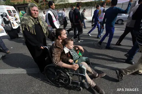 Palestinians and physically challenged people take part in a rally marking the International Day of Persons with Disabilities in Gaza City on Dec. 04, 2013. According to a United Nations report on disabilities, physical,...