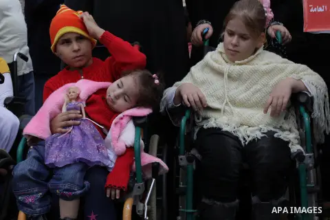 Palestinians and physically challenged people take part in a rally marking the International Day of Persons with Disabilities in Gaza City on Dec. 04, 2013. According to a United Nations report on disabilities, physical,...