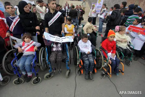 Palestinians and physically challenged people take part in a rally marking the International Day of Persons with Disabilities in Gaza City on Dec. 04, 2013. According to a United Nations report on disabilities, physical,...