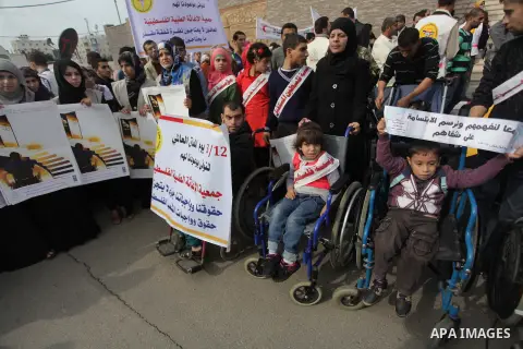 Palestinians and physically challenged people take part in a rally marking the International Day of Persons with Disabilities in Gaza City on Dec. 04, 2013. According to a United Nations report on disabilities, physical,...