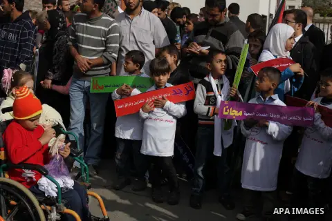 Palestinians and physically challenged people take part in a rally marking the International Day of Persons with Disabilities in Gaza City on Dec. 04, 2013. According to a United Nations report on disabilities, physical,...