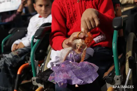 Palestinians and physically challenged people take part in a rally marking the International Day of Persons with Disabilities in Gaza City on Dec. 04, 2013. According to a United Nations report on disabilities, physical,...