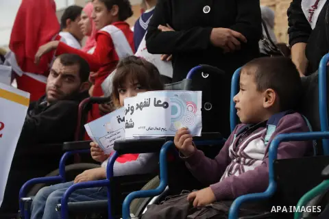 Palestinians and physically challenged people take part in a rally marking the International Day of Persons with Disabilities in Gaza City on Dec. 04, 2013. According to a United Nations report on disabilities, physical,...