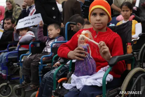 Palestinians and physically challenged people take part in a rally marking the International Day of Persons with Disabilities in Gaza City on Dec. 04, 2013. According to a United Nations report on disabilities, physical,...