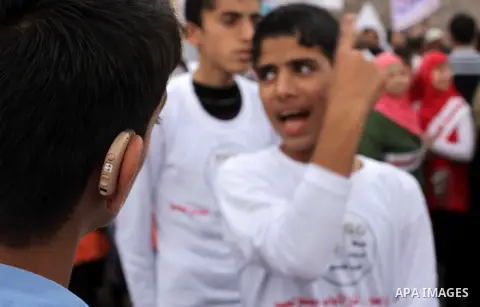 Palestinians and physically challenged people take part in a rally marking the International Day of Persons with Disabilities in Gaza City on Dec. 04, 2013. According to a United Nations report on disabilities, physical,...