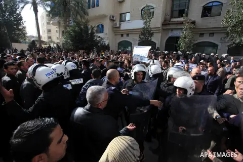 Palestinian teachers argue with riot policemen during a demonstration outside the court, in the West Bank City of Ramallah, Dec. 04, 2013. The Union organized regular strikes in the first half of 2013 to protest unpaid s...