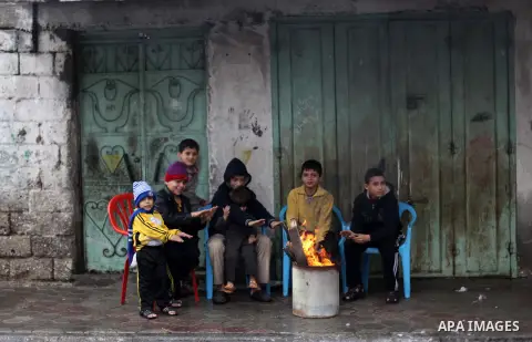 Palestinians warm themselves as wintry weather swept through the region, in Gaza city, on Dec. 05, 2013. Photo by Ashraf Amra