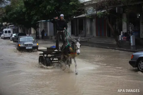 A Palestinian man rides his cart in a flooded street after a torrential rains Gaza city, on Dec. 05, 2013. Photo by Ashraf Amra