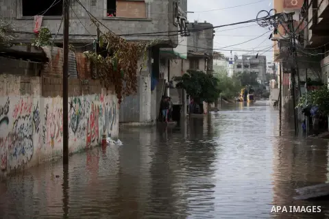 Palestinians walk past in a flooded street after a torrential rains in Gaza city, on Dec. 05, 2013. Photo by Ashraf Amra