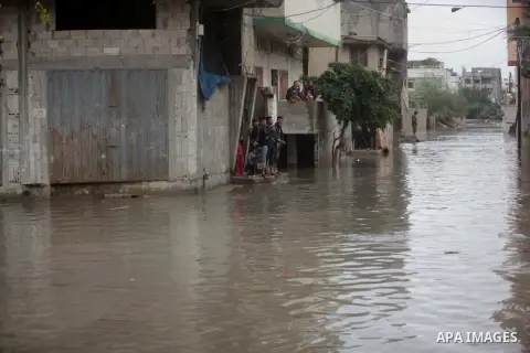 Palestinians walk past in a flooded street after a torrential rains in Gaza city, on Dec. 05, 2013. Photo by Ashraf Amra