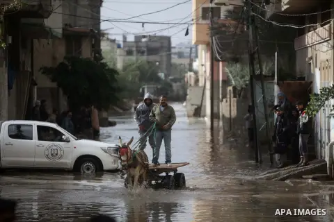 A Palestinian man rides his cart in a flooded street after a torrential rains Gaza city, on Dec. 05, 2013. Photo by Ashraf Amra