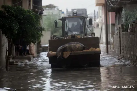 Palestinian bulldozer transfer a dead donkey from flooded street after a torrential rains Gaza city, on Dec. 05, 2013. Photo by Ashraf Amra