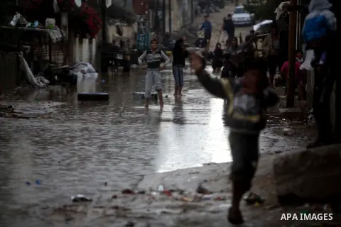 Palestinians walk past in a flooded street after a torrential rains in Gaza city, on Dec. 05, 2013. Photo by Ashraf Amra