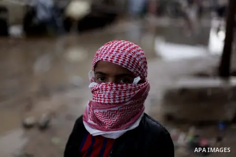 A Palestinian boy poses for a photograph amid a flooded street after a torrential rains Gaza city, on Dec. 05, 2013. Photo by Ashraf Amra