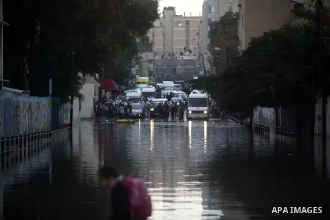 A Palestinian school girl walks past a flooded street following heavy rainfall in Gaza City on December 5, 2013. Photo by Ashraf Amra