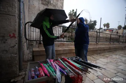 A Palestinian man sells umbrellas during a rainy day in Jerusalem's Old City, Dec. 05, 2013. Photo by Saeed Qaq