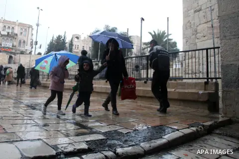 Palestinians walk in front of Damascus gate during a rainy day, in Jerusalem's Old City, Dec. 05, 2013. Photo by Saeed Qaq