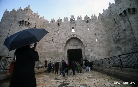 Palestinians walk in front of Damascus gate during a rainy day, in Jerusalem's Old City, Dec. 05, 2013. Photo by Saeed Qaq