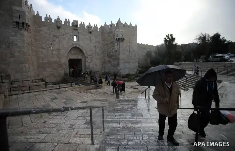 Palestinians walk in front of Damascus gate during a rainy day, in Jerusalem's Old City, Dec. 05, 2013. Photo by Saeed Qaq