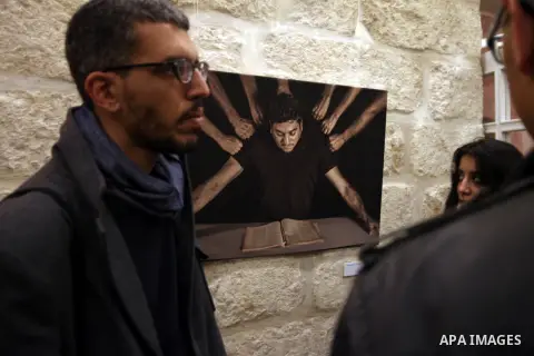 Palestinians attend a photogallery named 'Room Four', organised by French culture center in Jerusalem on Dec. 05, 2013. The photos by the artist Ashraf Dowani displayed in the photogallery and reflected the suffering of...