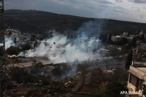 Palestinian protesters run seek for cover from tear gas canisters fired by Israeli security forces as clashes broke out during a demonstration against the expropriation of Palestinian land by Israel in the village of Kfa...