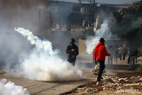 Palestinian protesters run seek for cover from tear gas canisters fired by Israeli security forces as clashes broke out during a demonstration against the expropriation of Palestinian land by Israel in the village of Kfa...