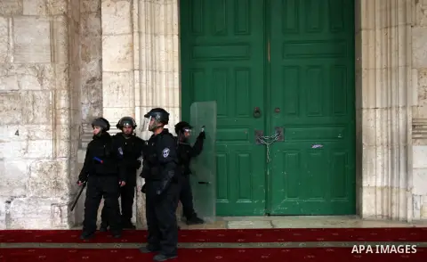 Israeli riot police stand at the entrance of al-Aqsa mosque during clashes with stone-throwers following Friday prayers at Jerusalem's al-Aqsa mosque compound, on December 6, 2013. Israeli police hurled stun grenades to...