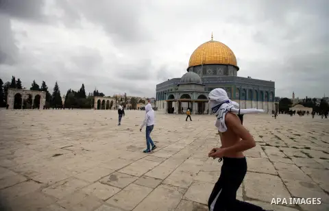 Palestinian protesters throw stones towards Israeli riot police during clashes following Friday prayers at Jerusalem's al-Aqsa mosque compound, on December 6, 2013. Israeli police hurled stun grenades to disperse stone-t...