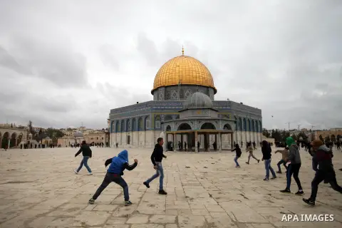 Palestinian protesters throw stones towards Israeli riot police during clashes following Friday prayers at Jerusalem's al-Aqsa mosque compound, on December 6, 2013. Israeli police hurled stun grenades to disperse stone-t...