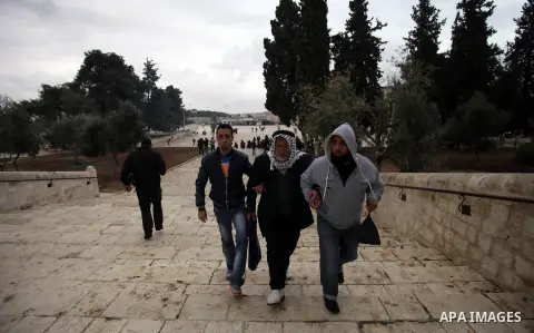 Palestinian worshipers help an old man during clashes between Israeli riot police and stone-throwers at Jerusalem's al-Aqsa mosque compound following Friday prayers, on December 6, 2013. Israeli police hurled stun grenad...